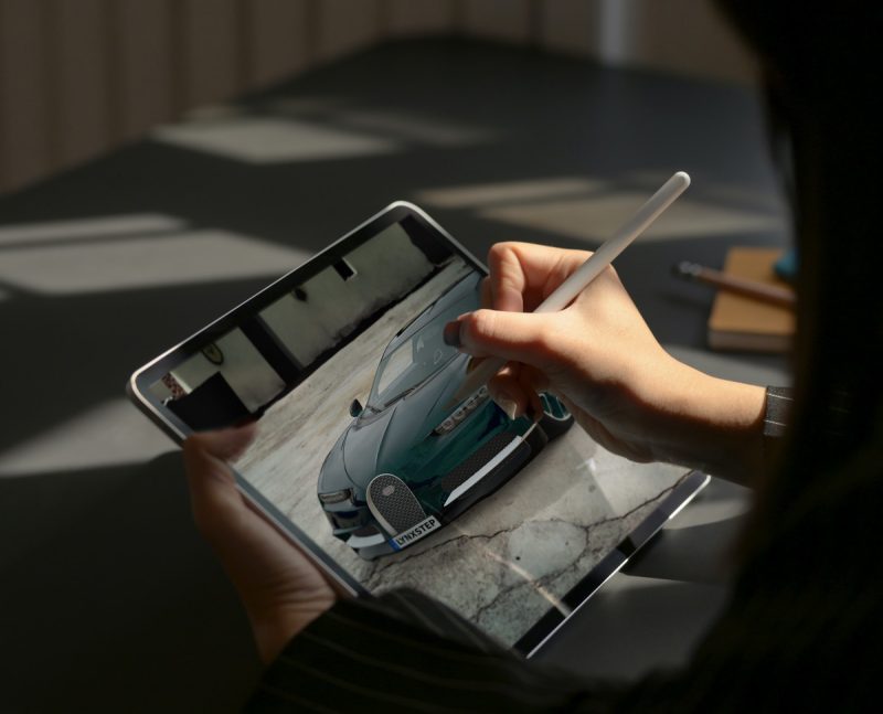 A person using a 3D car configurator on a tablet
